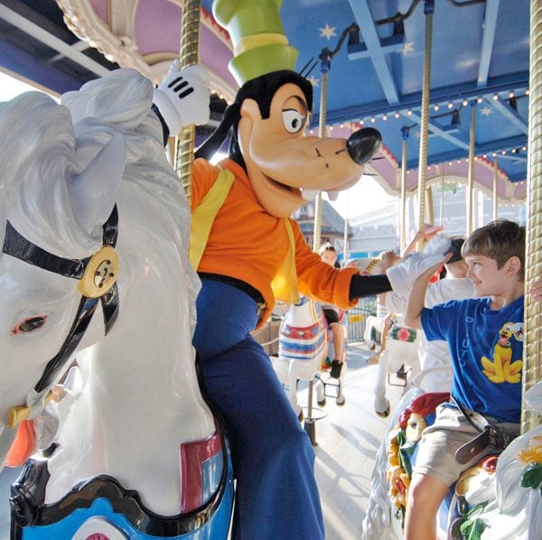 Goofy high fiving little boy on a horse