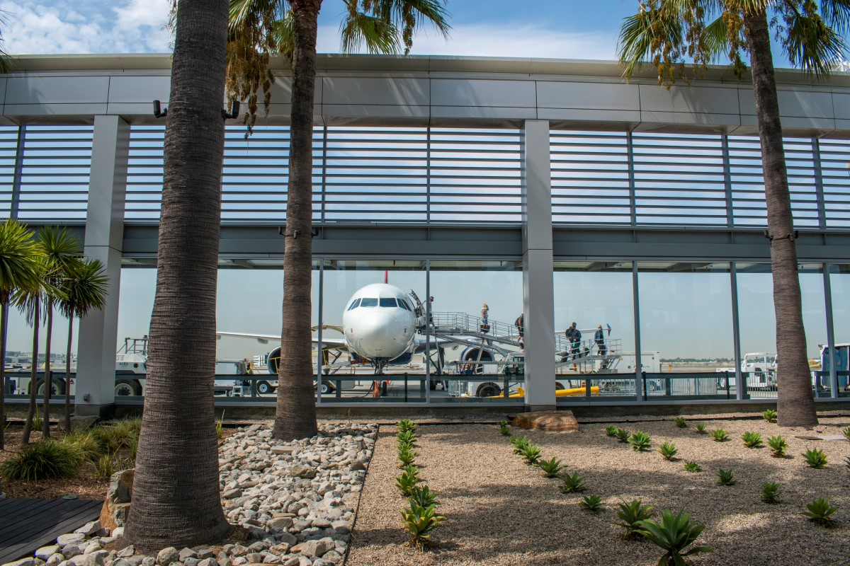 Outside area of Long Beach Airport with view of passengers departing plane