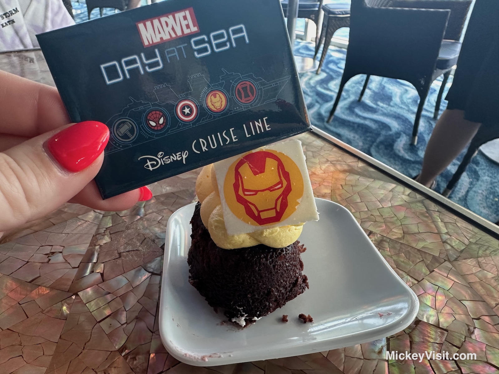 Marvel Day at Sea pin held over dessert