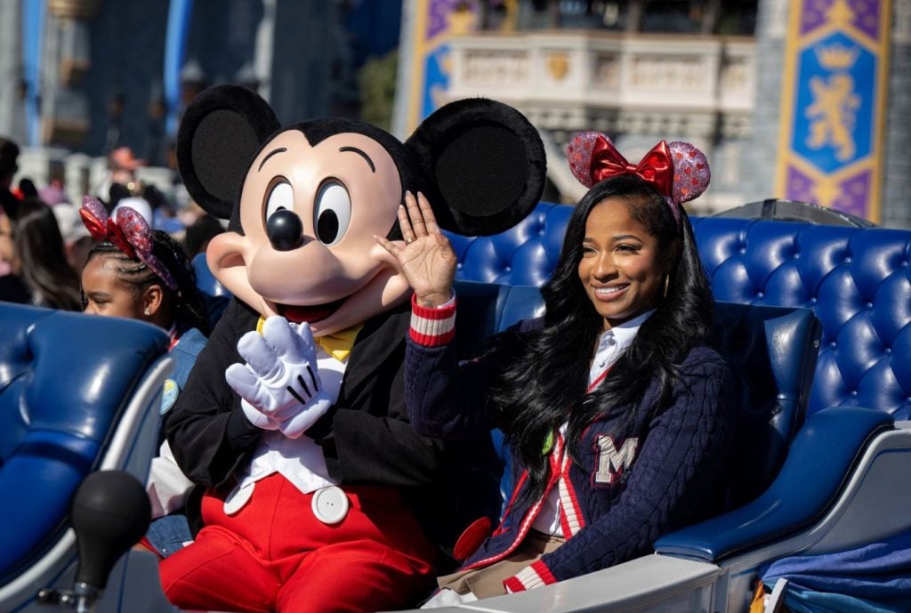 Toya Johnson-Rushing rides along with Mickey Mouse at Magic Kingdom to kick off Black History Month celebrations