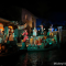 Pirates of the Caribbean scene at Disneyland featuring animatronic prates in a colorful nighttime village setting along the water