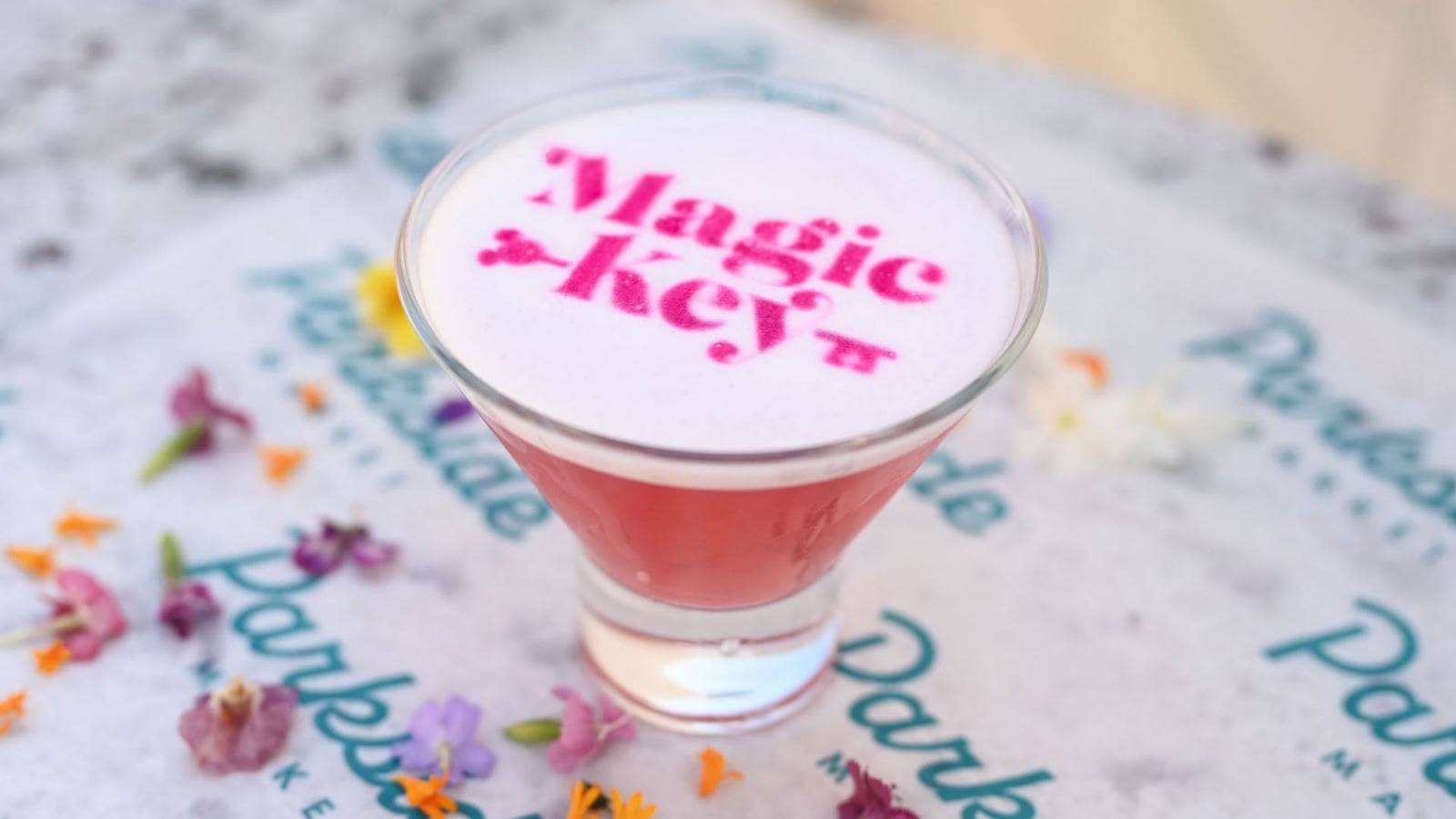 Drink with the Magic Key logo in pink text on top