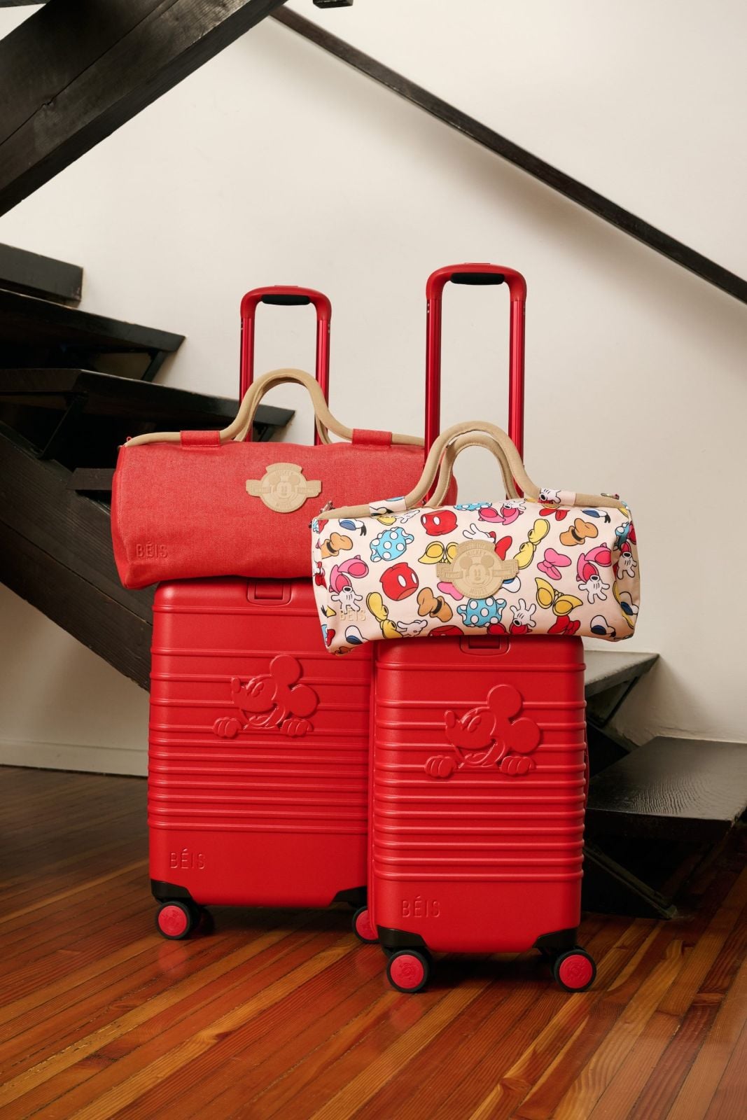 Duffle bags on top of red suitcases