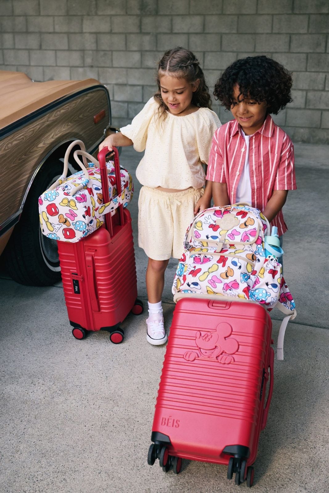 Kids with red roller suitcases