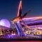 Monorail moving in front of large fake rocketship