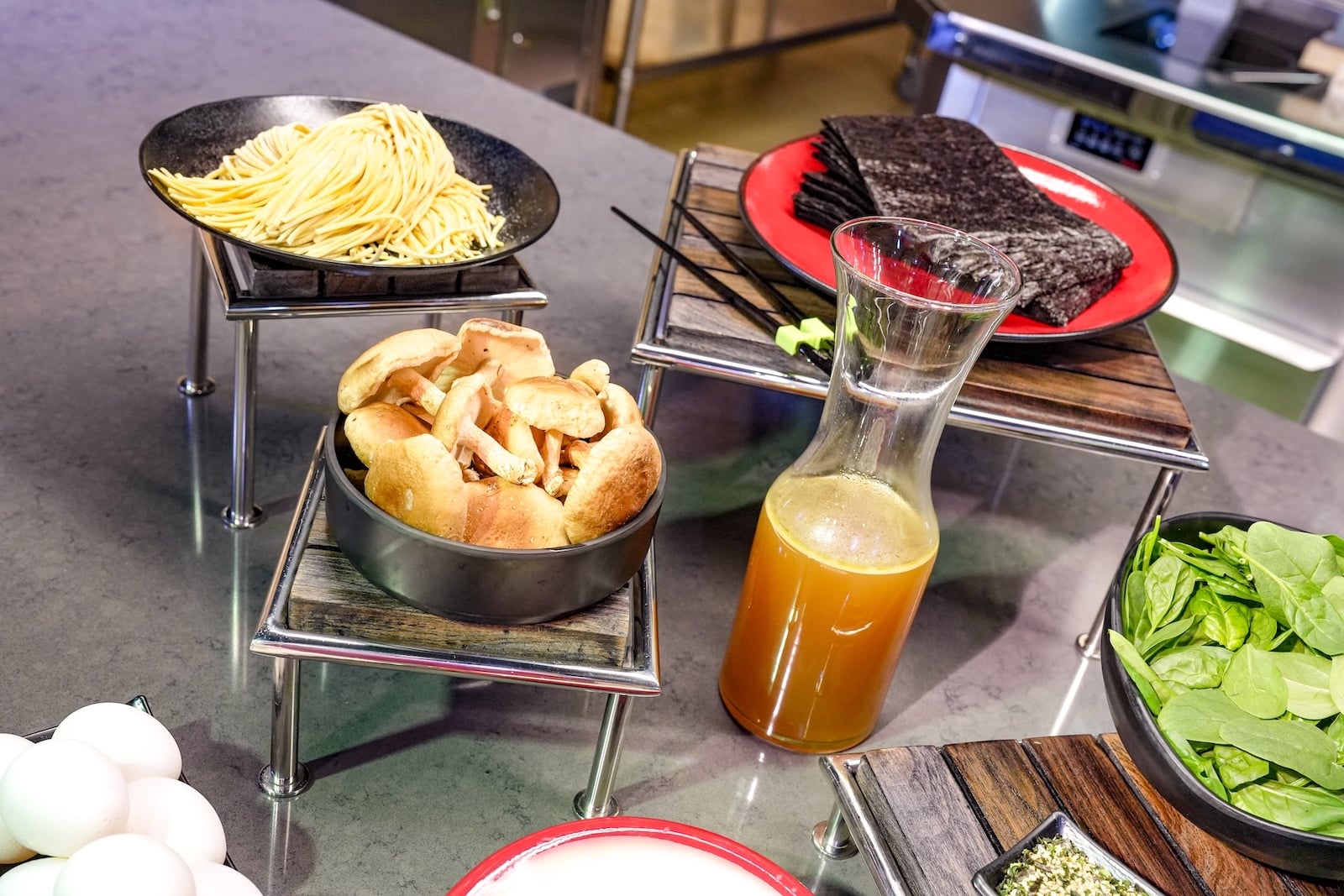 Spread of food including ramen, greens, and bread