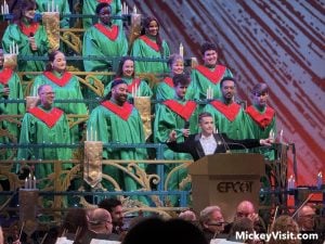 Jordan Fisher at a podium on stage in front of a choir