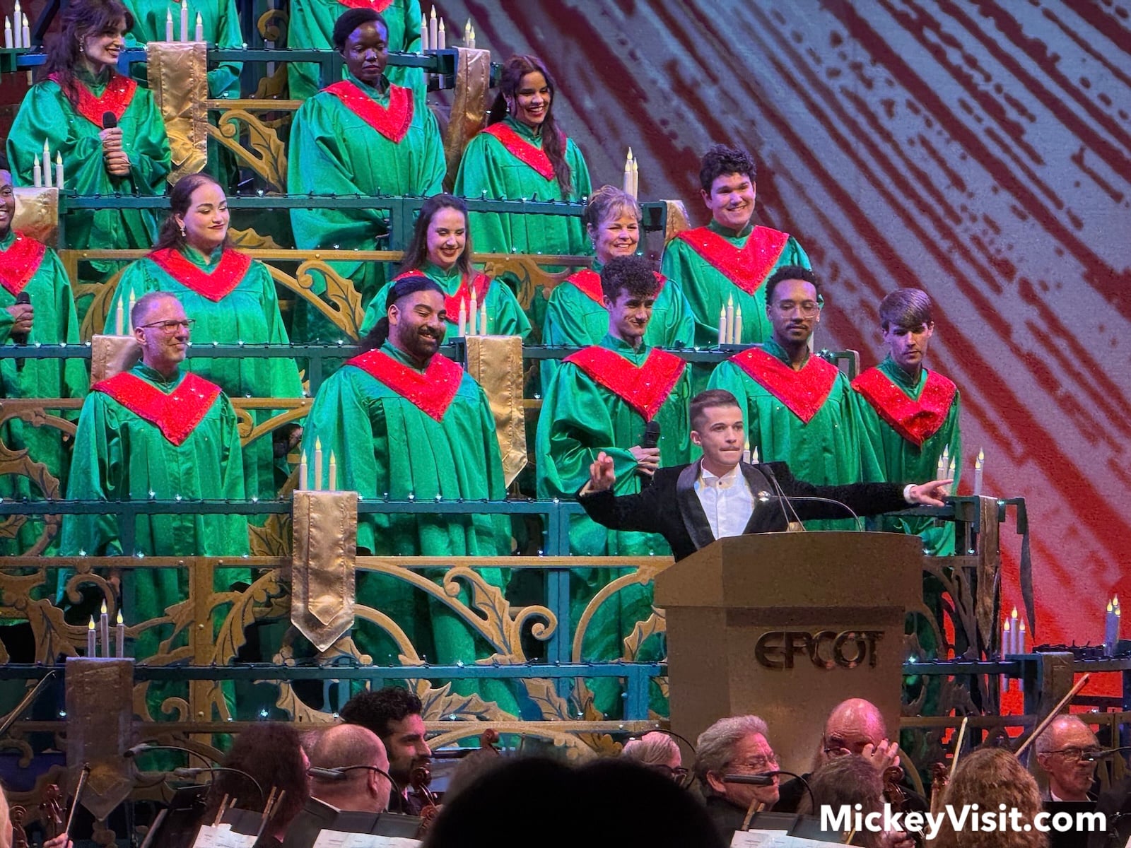 Jordan Fisher at a podium on stage in front of a choir