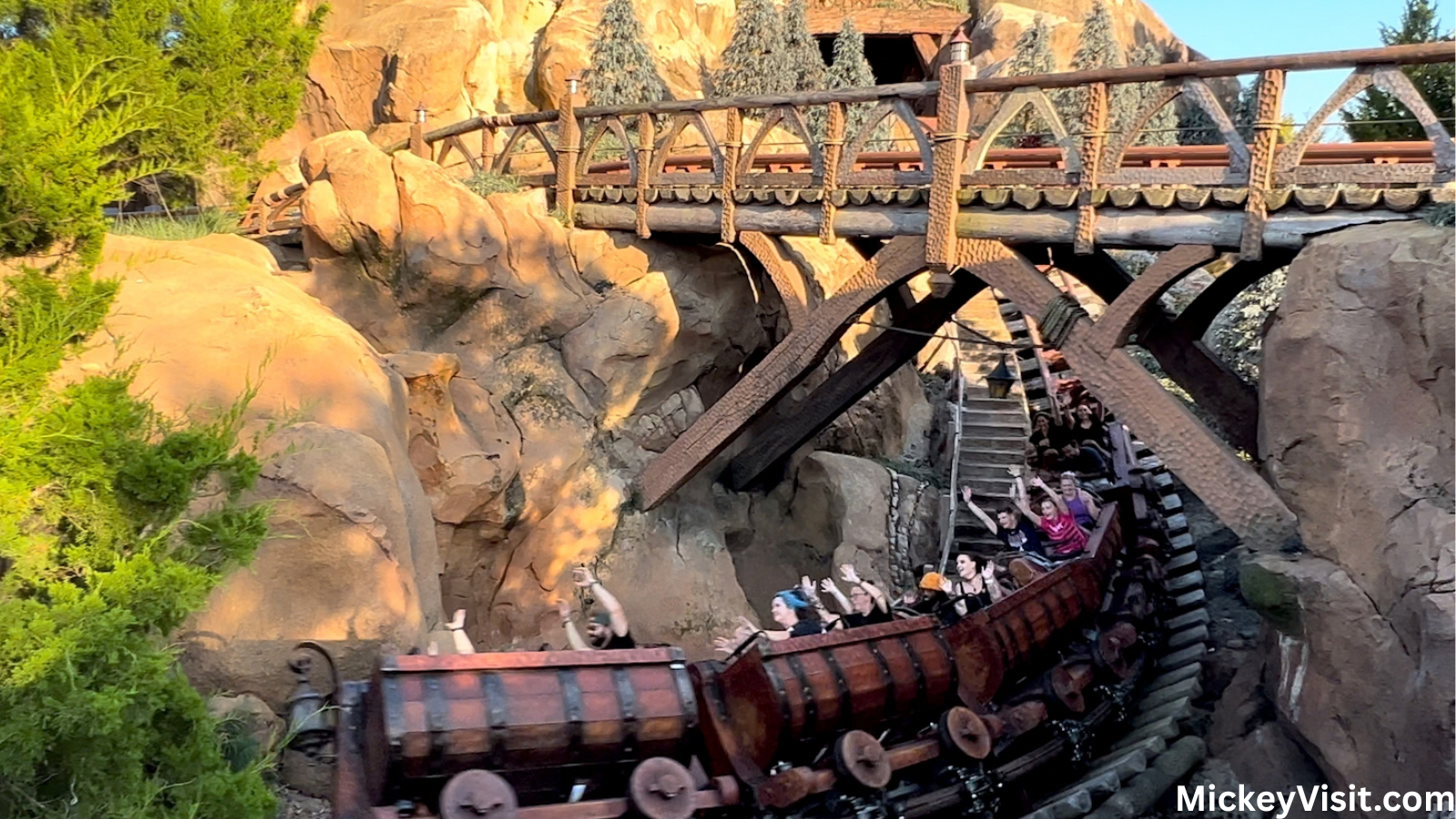 Seven Dwarfs Mine Train rollercoaster traveling under a bridge.