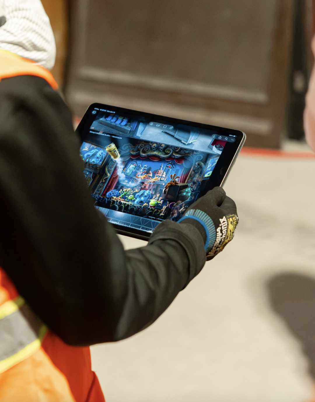 Person holding tablet with Monsters Inc illustration